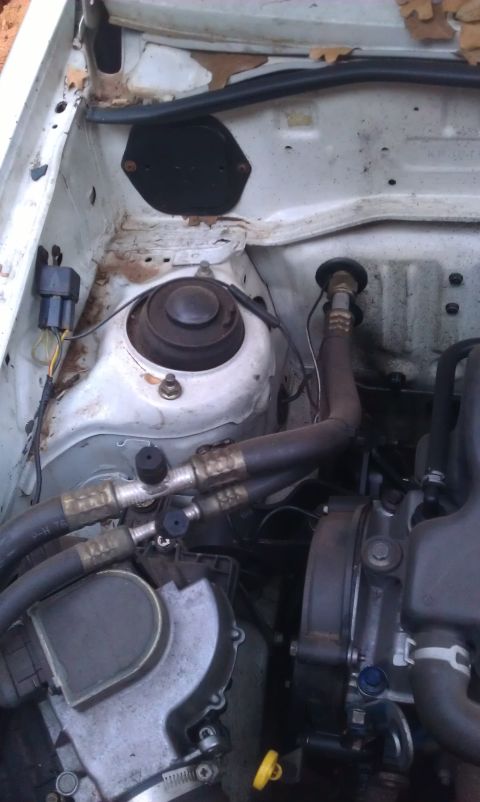 1991 Ford Festiva - Close-up view of a car's engine compartment, showing various hoses and mechanical components.