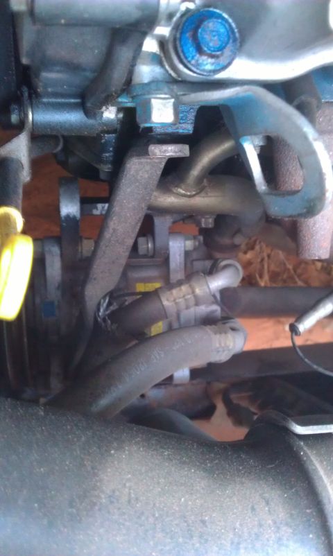 1991 Ford Festiva - Close-up view of engine components, including hoses and a metal bracket.