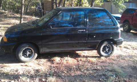 1991 Ford Festiva - Side view of a black 1991 Ford Festiva hatchback.