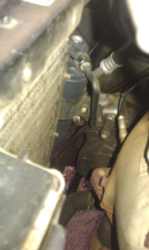 1991 Ford Festiva - Close-up view of engine bay components, including radiator and exhaust parts.