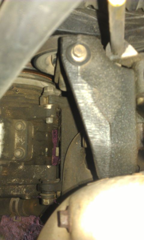 1991 Ford Festiva - Close-up view of an engine bracket and pulley system, likely from a vehicle's engine bay.