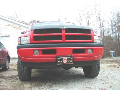 1997 Ford Taurus - A red Dodge Ram pickup truck is seen from the front, parked next to another vehicle.