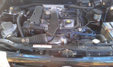 1991 Ford Festiva - The engine bay of a 1991 Ford Festiva shows its internal components.