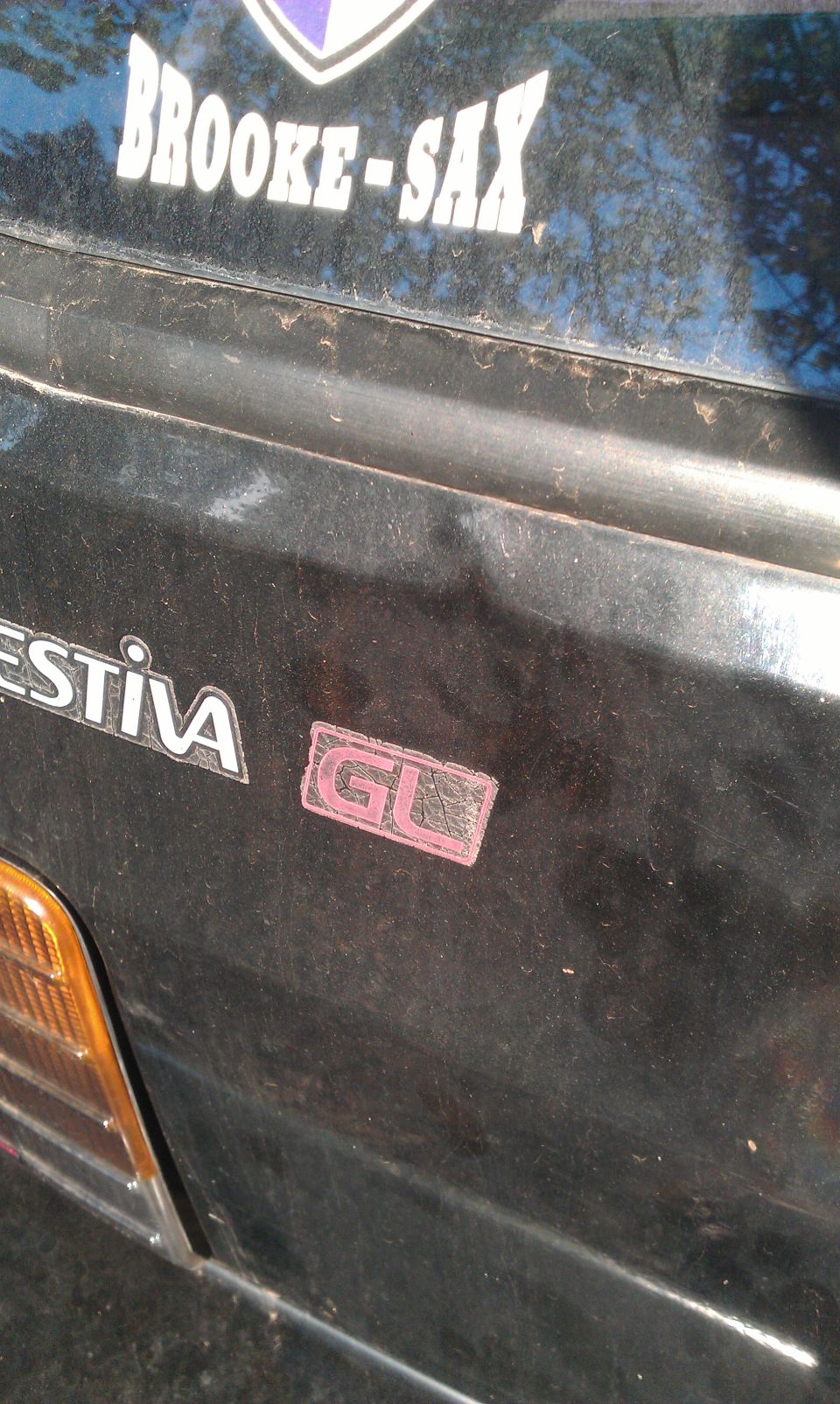 Rear of a Ford Festiva with a GL badge and a BROOKE-SAX sticker