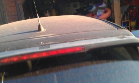 1991 Ford Festiva - The rear spoiler and third brake light are visible on the roof of a dusty vehicle.