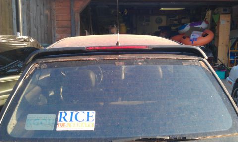 1991 Ford Festiva - Rear view of a dusty car, showing stickers on the window and a Supermotors logo.