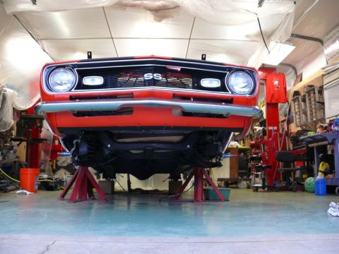 1968 Chevrolet Camaro - The front of a red 1968 Chevrolet Camaro is raised on jack stands, revealing the underside and the SS emblem on the grille.