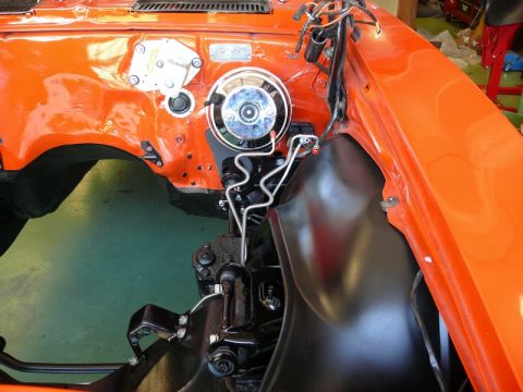 1968 Chevrolet Camaro - The engine bay of an orange 1968 Chevrolet Camaro shows the brake booster and associated lines.