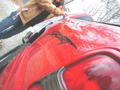 1997 Ford Taurus - A red car with a black decal on its rear is visible, along with a Supermotors logo.