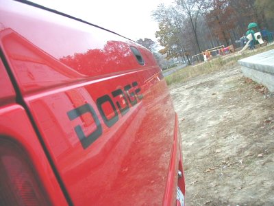 1997 Ford Taurus - Side view of a red Dodge van with the brand name visible on the panel.