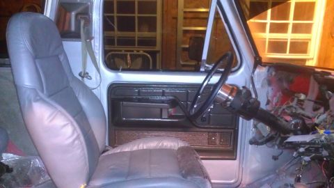 1978 Ford Bronco - Interior view of a vehicle showing seats, dashboard wiring, and a steering column.