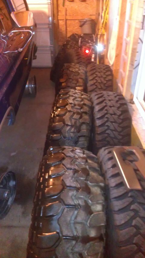 1978 Ford Bronco - A collection of aggressive off-road tires are stored in a garage, ready for adventure.