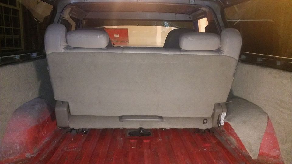 Rear interior view of a vehicle showing a folded-down seat and red-painted cargo bed