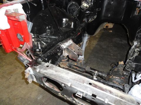 1989 Jeep Cherokee - The front end of a vehicle is shown, with the engine bay and frame exposed, suggesting ongoing repairs or modifications.