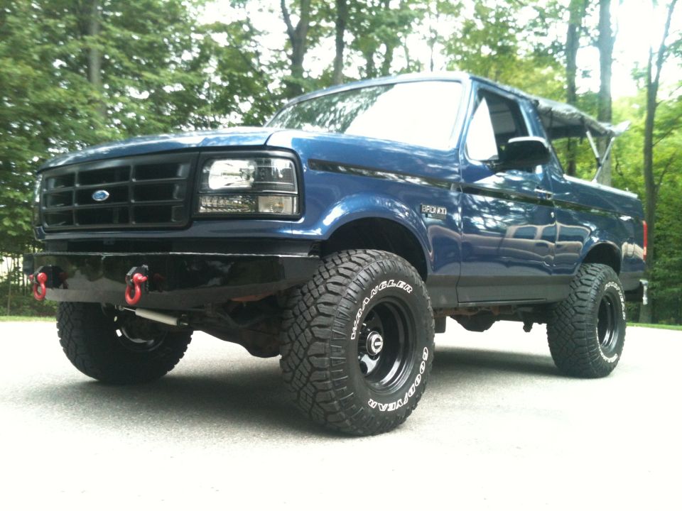 Blue 1996 Ford Bronco with aftermarket bumper and large tires