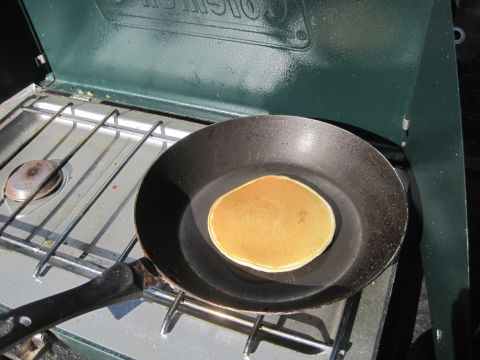 1989 Ford Bronco - A pancake is being cooked on a portable stove in a frying pan.