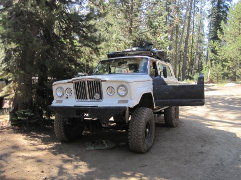 1989 Ford Bronco - This modified Jeep Gladiator J-series pickup truck is shown from a three-quarter front view in a wooded area.