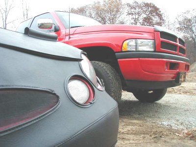 1997 Ford Taurus - Red pickup truck with a dark vehicle in the foreground.