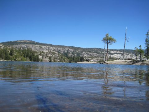1989 Ford Bronco - A lake scene with mountains and trees under a clear blue sky.