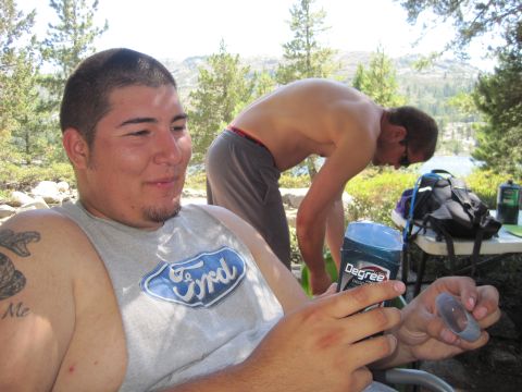 1989 Ford Bronco - Two men are at a campsite with a lake and trees in the background. One man is wearing a Ford t-shirt.