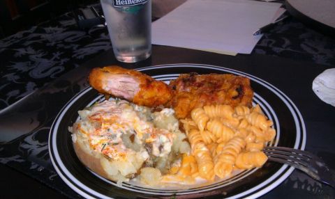 1989 Ford Bronco - A meal consisting of fried chicken, a loaded baked potato, and pasta is served on a plate with a glass of Heineken.