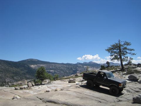 1989 Ford Bronco - This Ford pickup truck is parked on a rocky outcrop with a scenic mountain vista behind it.