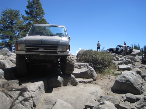 1989 Ford Bronco - This lifted 1989 Ford Bronco navigates a rocky trail, with another Jeep visible in the background.