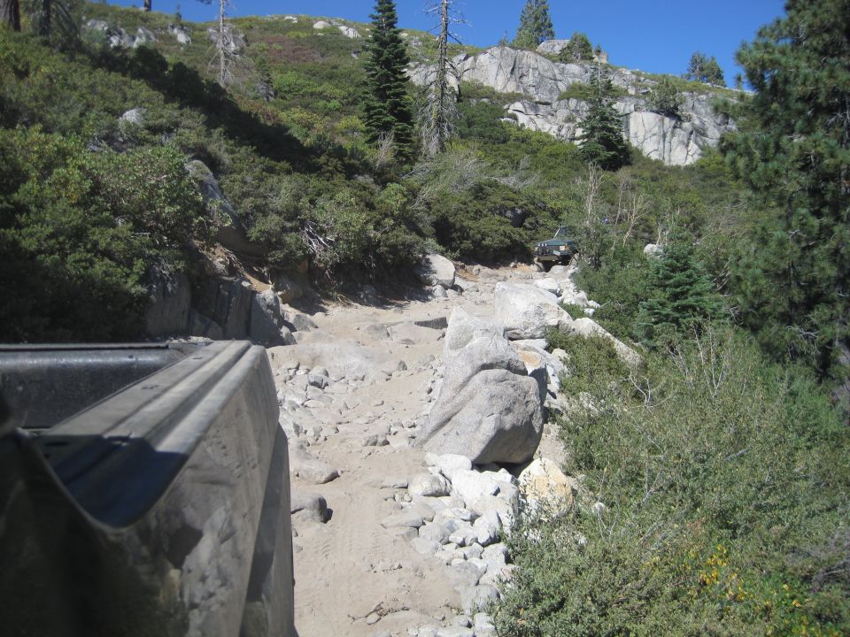 Green SUV on a rocky off-road trail