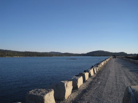 1989 Ford Bronco - A scenic view of a lake and a road on a dam under a clear blue sky.