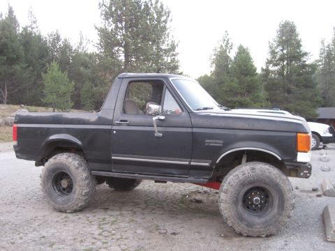 1989 Ford Bronco - This lifted Ford Bronco features oversized tires and a modified suspension system, suggesting off-road capabilities.