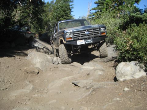 1986 Ford Bronco - This 1986 Ford Bronco tackles a challenging rocky off-road path, with a second vehicle following.