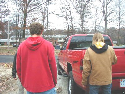 1997 Ford Taurus - A red pickup truck is parked on a street with trees and houses in the background.