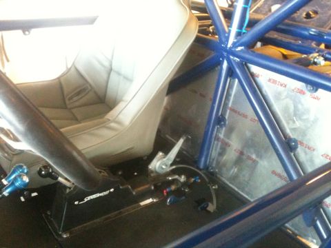 1966 Ford Bronco - Interior view of a custom vehicle with a roll cage and racing seat.