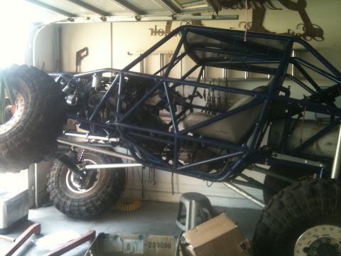 1966 Ford Bronco - A custom-built buggy with a prominent blue roll cage and large off-road tires is shown in a garage setting.