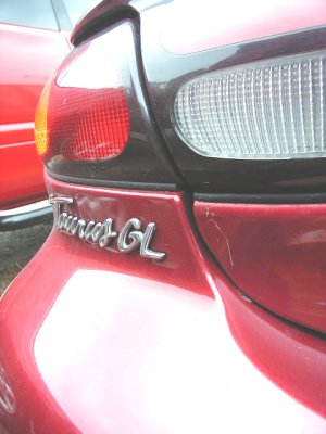 1997 Ford Taurus - Rear detail of a red 1997 Ford Taurus GL, showing the taillight and 'Taurus GL' badging.