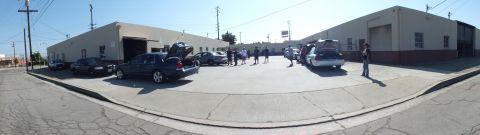 2003 Ford Crown Victoria - Stitched panorama of a meet lot, sedans parked along shops with attendees gathered