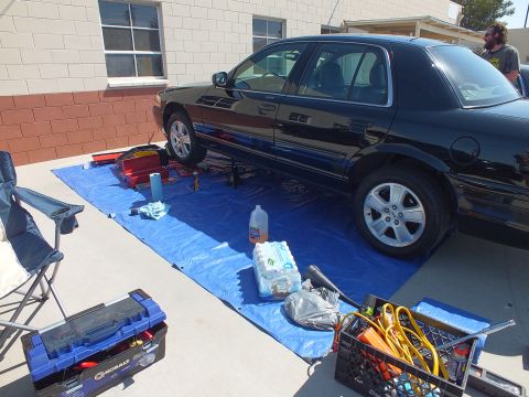 2003 Ford Crown Victoria - Overhead-angle of a black sedan lifted for service with a Kobalt toolbox and tools laid out nearby.