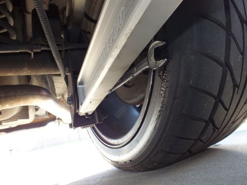 2003 Ford Crown Victoria - Close underside shot showing rear tire, coil spring, exhaust pipe and frame rail of a lowered car