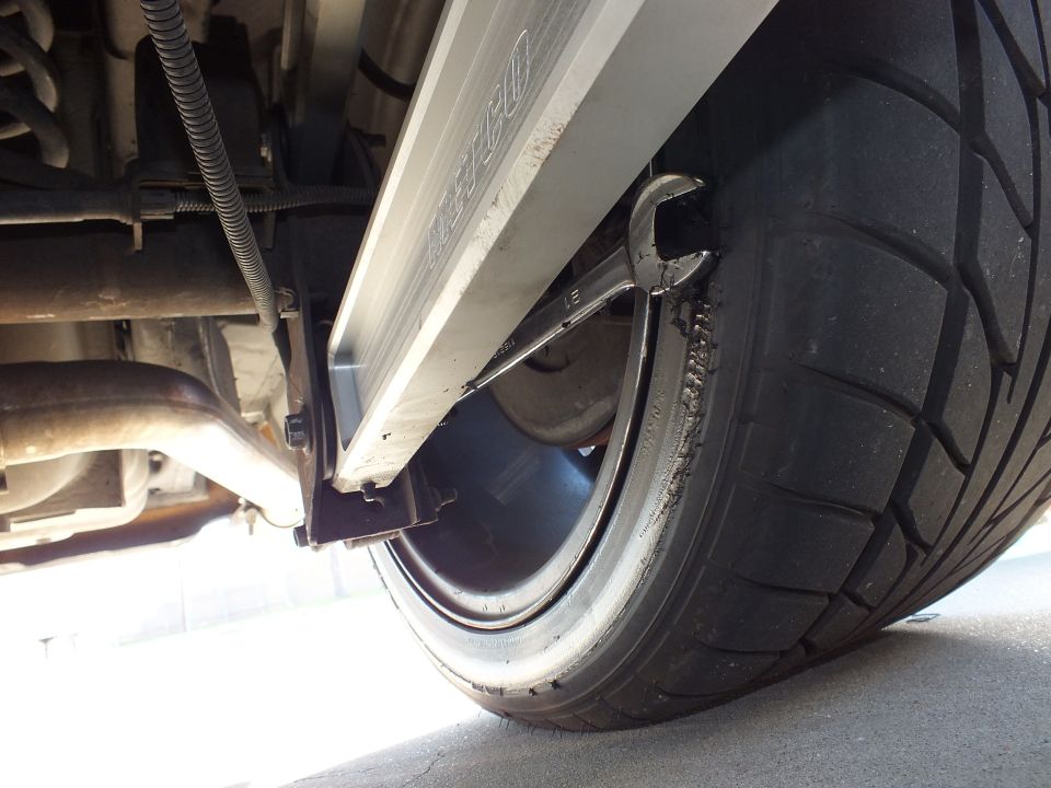 Underbody view of rear wheel, suspension and exhaust on lowered vehicle