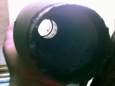 2001 Mercury Grand Marquis - Close-up view inside an exhaust resonator, showing the internal perforated tube structure.