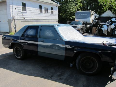 1991 Ford LTD Crown Victoria - A Ford Crown Victoria is being prepped for painting, with its windows covered and parts of the body in primer.