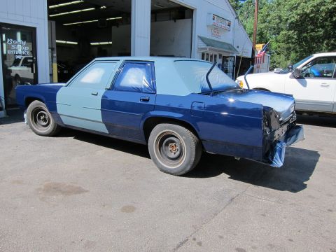 1991 Ford LTD Crown Victoria - Ford Crown Victoria LTD in body shop for paintwork, showing masked and painted sections.