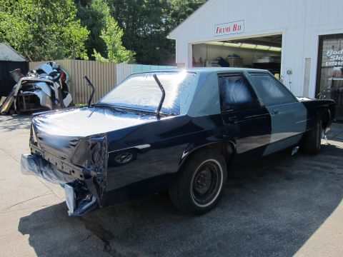 1991 Ford LTD Crown Victoria - Ford Crown Victoria LTD undergoing bodywork and paint preparation at a shop.