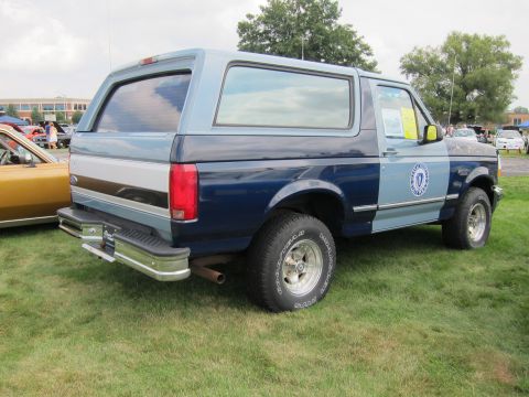 1991 Ford LTD Crown Victoria - Rear quarter view of a two-tone blue Ford Bronco with chrome bumper and door seal parked on a grassy show field.