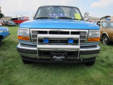 1991 Ford LTD Crown Victoria - Head-on view of a two-tone blue Ford Bronco showing its grille, chrome push bar, fog lamps and side spotlight.