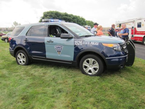 1991 Ford LTD Crown Victoria - two-tone blue Ford Explorer marked 1526 State Police with a push bar and roof lights, parked on grass near a red fire apparatus.