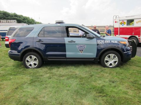 1991 Ford LTD Crown Victoria - side profile of a two-tone blue Ford Explorer marked 1526 State Police, parked on grass beside a red fire truck.