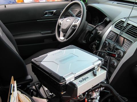 1991 Ford LTD Crown Victoria - cockpit of a police SUV with a Ford steering wheel and a rugged laptop secured to a Havis center-console mount.