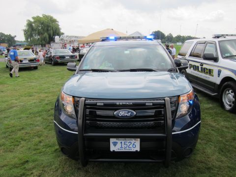 1991 Ford LTD Crown Victoria - front of a blue Ford Explorer State Police SUV with a Setina push bar and 1526 plate, parked on grass near other police cars.