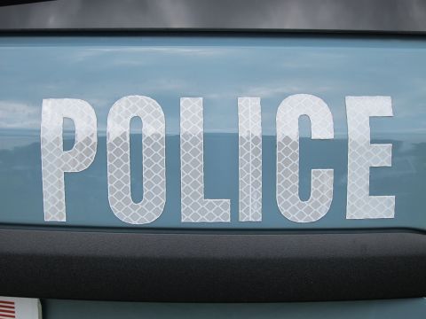 1991 Ford LTD Crown Victoria - Close-up of reflective white block lettering spelling POLICE applied across a light-blue painted vehicle body panel.